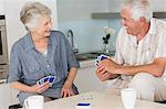 Happy senior couple playing a card game