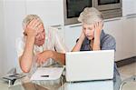 Worried senior couple using the laptop to pay bills