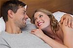 Happy relaxed young couple together in bed