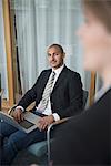 Mid adult man in conference room with laptop, Stockholm, Sweden