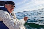 Senior man sailing, Grundsund, Bohuslan, Sweden