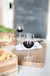 Wineglass with red wine on cutting board