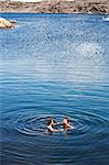 Mid adult couple swimming in sea, Bohuslan, Sweden