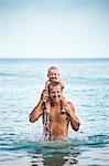 Father with baby in sea, Thailand