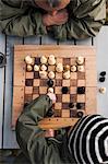 Boy with grandfather playing chess, high angle view