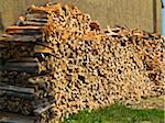 Stack of firewood next to building, Germany