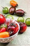 Colourful tomatoes, some in a bowl