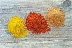 Three mounds of different spices from above