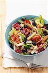 Pasta salad with olives, cherry tomatoes, iceberg lettuce and mozzarella