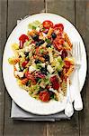 Pasta salad with olives, cherry tomatoes, iceberg lettuce and mozzarella