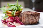 sirloin steak with red onions, tomatoes and rocket leaves