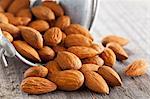 Whole almonds falling out of a metal bucket