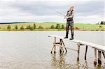 woman fishing on pier at pond