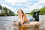 young woman fishing in pond during summer