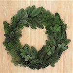 Christmas and winter spruce fir green wreath over oak background.