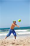 attractive young man playing volleyball on the beach summertime