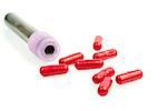test tube near red pills on white background