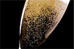 detail of a flute with a lot of champagne gold bubbles on black background