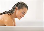 Young woman washing in bathtub