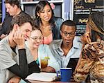 Happy group of five students studying in cafe