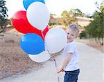 little cheerful boy holding colorful balloons and celebrating 4th of July