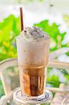 Iced coffee with whipped cream and sprinkle cocoa