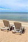 lovely white lounge chairs on the sea beach