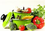 green pots full of vegetables (tomatoes, asparagus, mushrooms, broccoli) and pasta