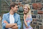 Hip young couple standing by steps on a sunny day in the city