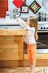 Little girl getting tableware from table case before dinner