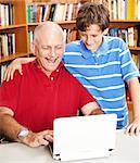 Son and father on the computer at the library.