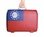 Used plastic suitcase with stains and scratches, printed with flag, Myanmar