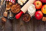 Ingredients for apple pie cooking. Fresh red apple, butter, flour, brown sugar, nuts and spices on a rustic wooden background.