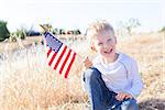 little boy holding american flag and celebrating 4th of July