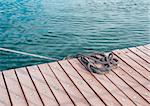 Coiled marine rope on wooden pier