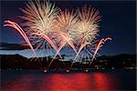 Lakefront Luino fireworks on the Maggiore lake in summer evening, Lombardy - Italy
