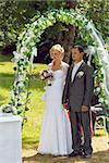 beautiful young couple in wedding ceremony outdoor, blond bride with flower and groom