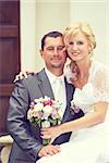 beautiful young wedding couple, blonde bride with flower and her groom, retro color tone