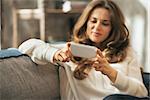 Closeup on young woman writing sms in loft apartment