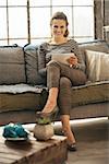 Happy young woman using tablet pc in loft apartment