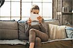 Young woman using tablet pc in loft apartment