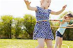 Low angle view of two girls playing with plastic hoops