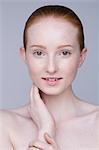 Close up portrait of young woman, hand on face