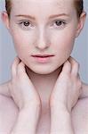 Close up portrait of young woman, hands on neck