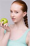 Portrait of young woman, holding green apple