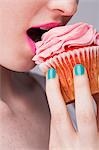 Cropped image of young woman holding cupcake