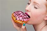 Young woman biting donut