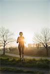 Young female runner, running at sunset