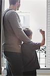 Boy launching paper plane from window