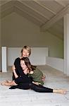 Mother and twelve year old daughter hugging on floor